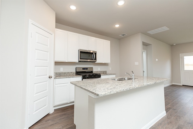 kitchen with stainless steel appliances, white cabinetry, an island with sink, and sink