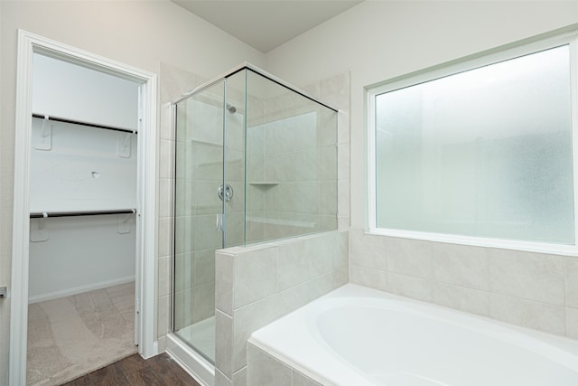 bathroom with hardwood / wood-style floors, a wealth of natural light, and shower with separate bathtub