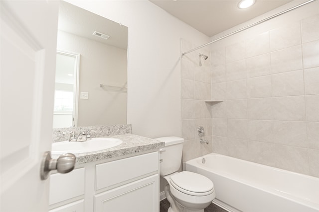 full bathroom featuring tiled shower / bath, toilet, and vanity