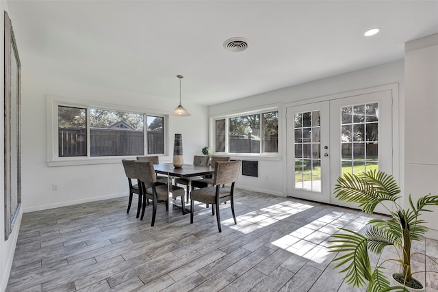 dining room featuring plenty of natural light, french doors, and light hardwood / wood-style flooring