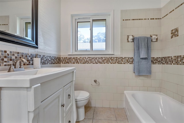 bathroom featuring a bathtub, vanity, tile walls, tile patterned flooring, and toilet