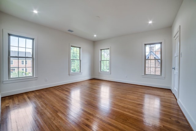 spare room with plenty of natural light and hardwood / wood-style flooring