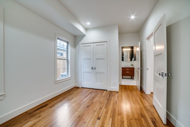 unfurnished bedroom with light hardwood / wood-style floors and a closet