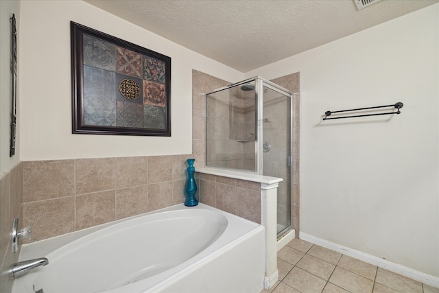 bathroom featuring tile patterned floors, independent shower and bath, and a textured ceiling