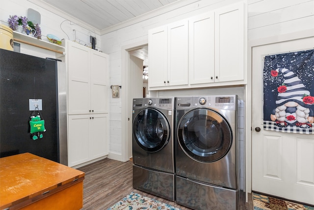 laundry area with washer and clothes dryer, hardwood / wood-style flooring, crown molding, and cabinets