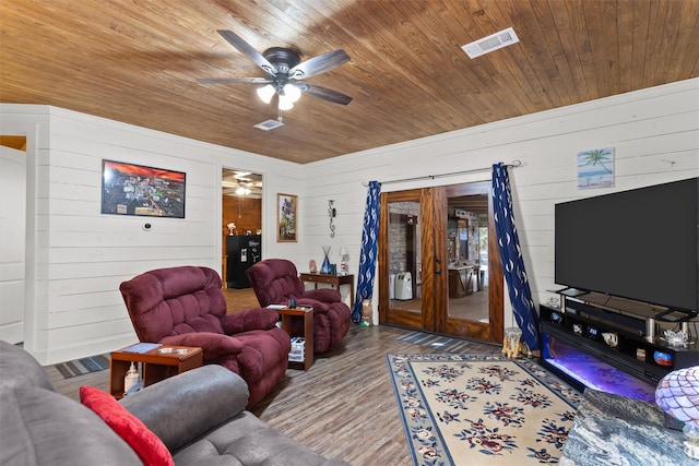 living room featuring hardwood / wood-style floors, ceiling fan, wooden walls, and wood ceiling