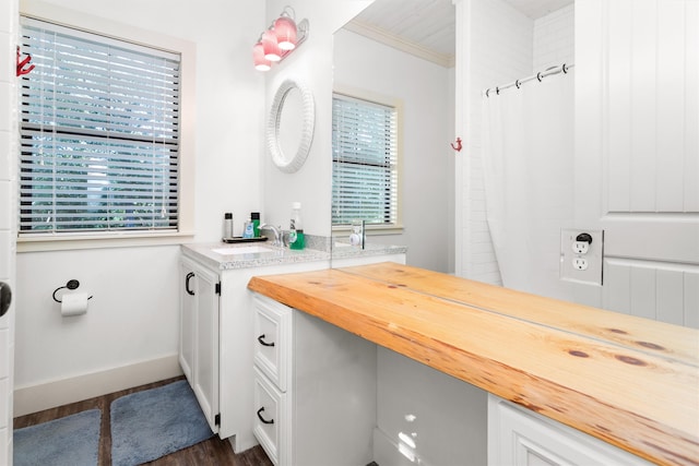 bathroom with sink, ornamental molding, and hardwood / wood-style flooring