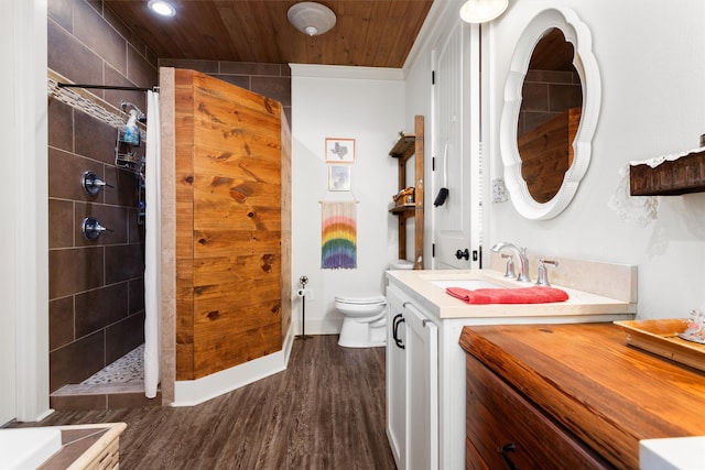 bathroom with wooden ceiling, wood-type flooring, tiled shower, toilet, and vanity