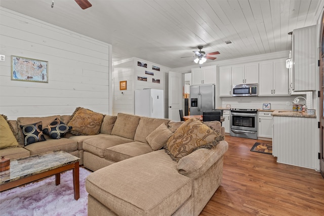 living room featuring hardwood / wood-style floors, ceiling fan, wooden ceiling, and sink