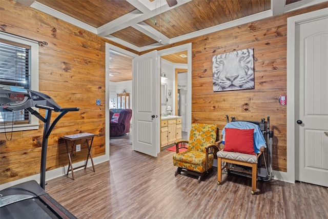 exercise room with wooden walls, crown molding, and hardwood / wood-style flooring