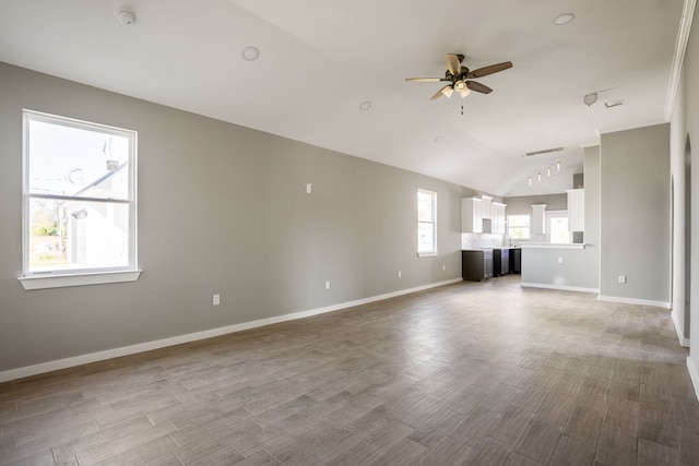 unfurnished living room with vaulted ceiling, hardwood / wood-style flooring, and ceiling fan