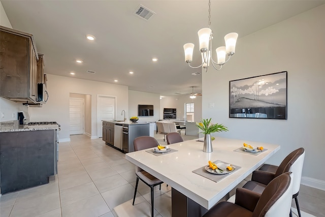 dining room featuring ceiling fan with notable chandelier, light tile patterned flooring, and sink