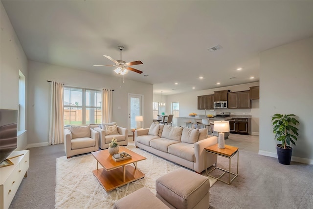 carpeted living room featuring ceiling fan