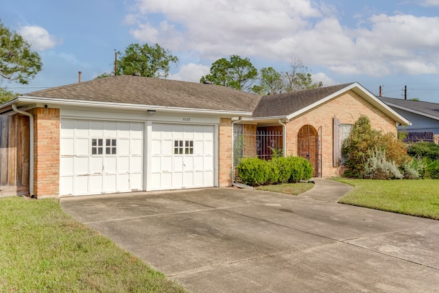 single story home featuring a garage and a front lawn