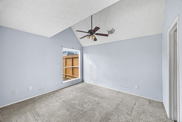 interior space with vaulted ceiling, carpet flooring, and a textured ceiling