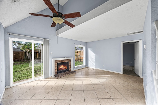 unfurnished living room featuring a fireplace, plenty of natural light, a textured ceiling, and lofted ceiling