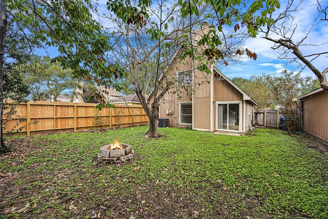 view of yard with central AC and a fire pit