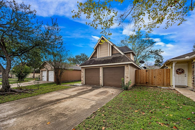 view of front facade with a garage, a front yard, and an outdoor structure