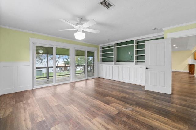 unfurnished living room with ceiling fan, dark hardwood / wood-style floors, built in shelves, and crown molding