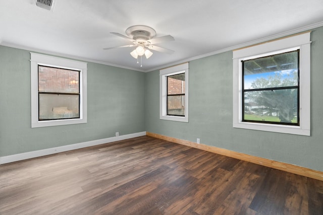 spare room with wood finished floors, visible vents, a wealth of natural light, and ceiling fan