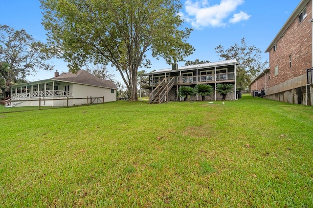view of yard featuring stairway, a deck, and fence