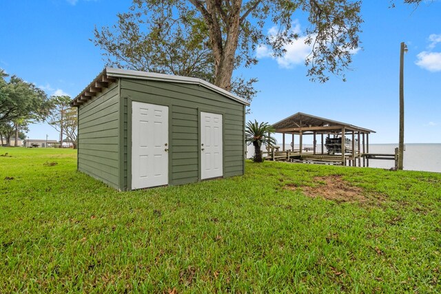 view of outbuilding with a water view and a yard