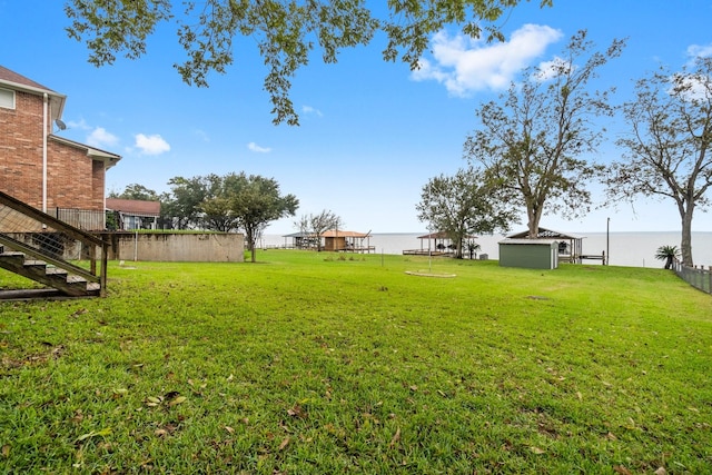 view of yard featuring fence, an outbuilding, and a shed