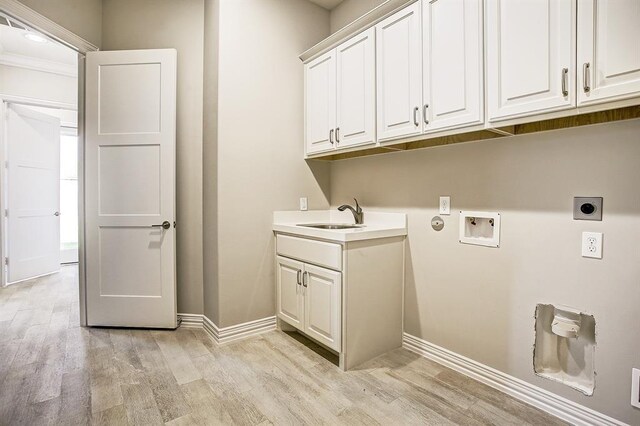 clothes washing area with sink, light hardwood / wood-style flooring, cabinets, washer hookup, and hookup for an electric dryer