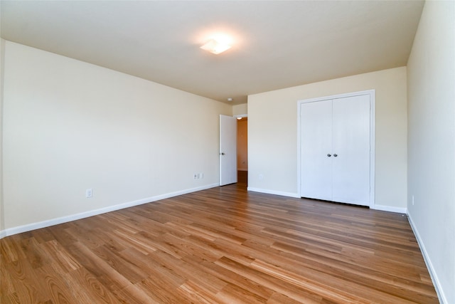 unfurnished bedroom with a closet and wood-type flooring