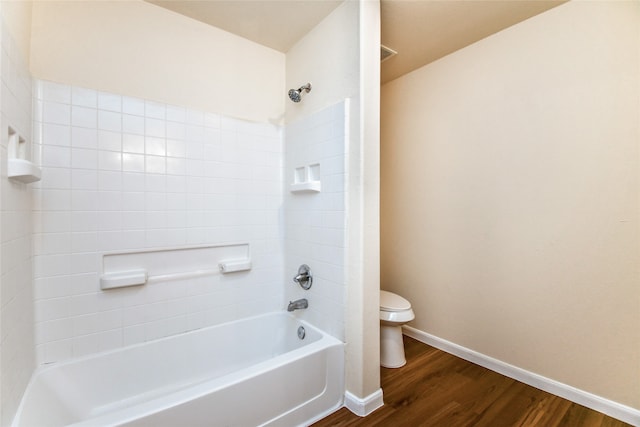 bathroom featuring hardwood / wood-style floors, toilet, and bathing tub / shower combination