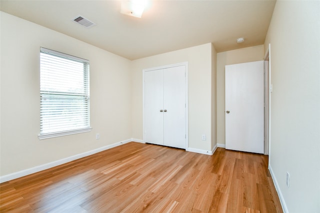 unfurnished bedroom featuring light hardwood / wood-style floors and a closet