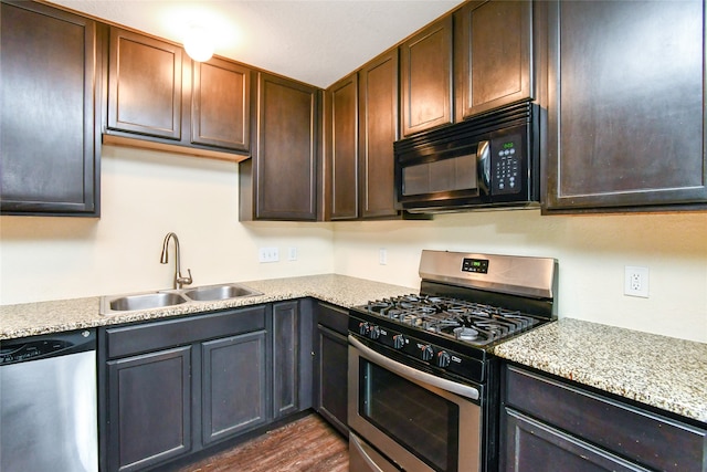 kitchen with dark hardwood / wood-style flooring, dark brown cabinetry, sink, and appliances with stainless steel finishes