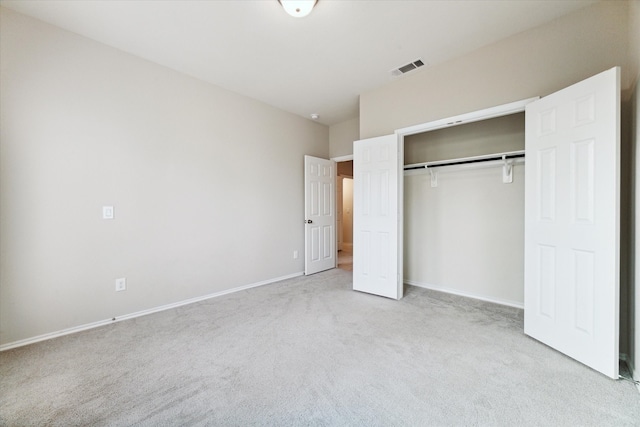 unfurnished bedroom featuring a closet and light colored carpet