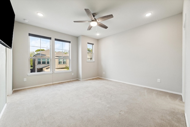 carpeted spare room featuring ceiling fan