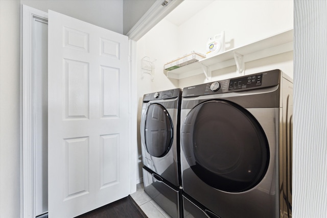 clothes washing area with washing machine and clothes dryer and tile patterned flooring