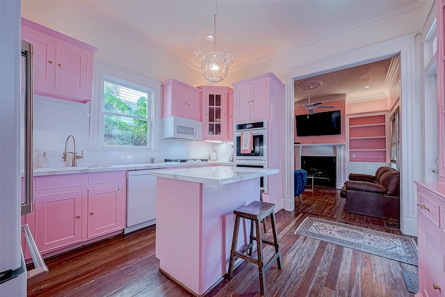 kitchen with sink, appliances with stainless steel finishes, hardwood / wood-style floors, hanging light fixtures, and a kitchen island