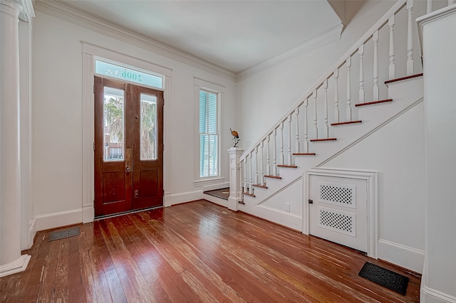 entryway featuring hardwood / wood-style flooring, ornate columns, and crown molding