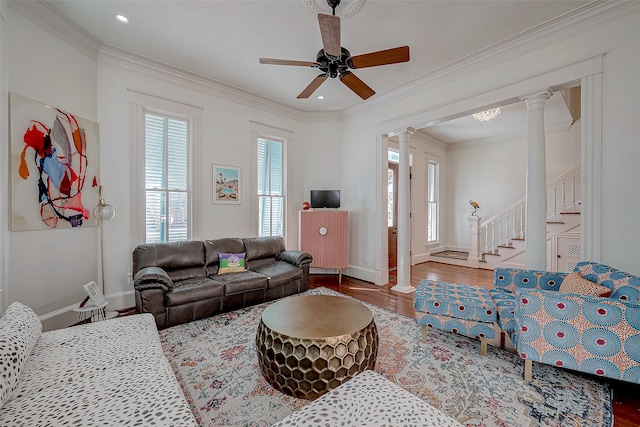 living room featuring decorative columns, wood-type flooring, ceiling fan, and crown molding