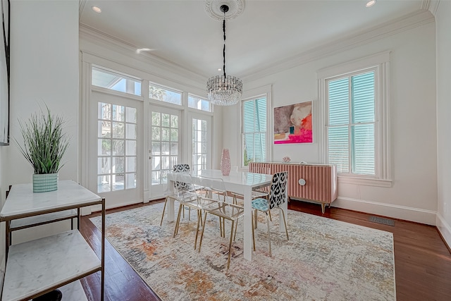 dining area with dark wood-type flooring, a healthy amount of sunlight, and crown molding