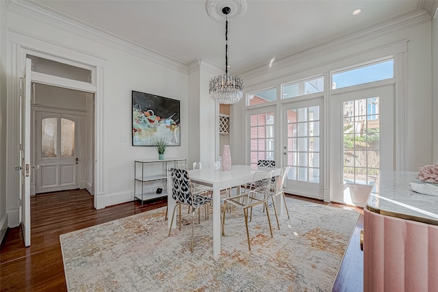 dining room with dark hardwood / wood-style floors, an inviting chandelier, and ornamental molding