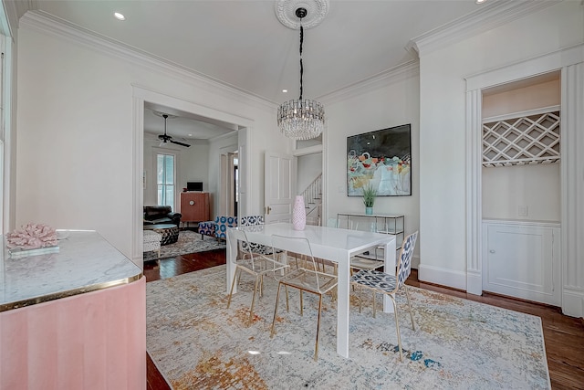 dining room featuring ornamental molding, ceiling fan with notable chandelier, and dark hardwood / wood-style floors