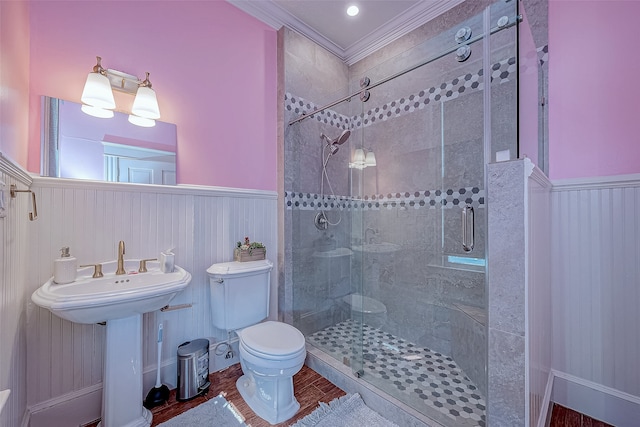 bathroom with toilet, hardwood / wood-style floors, a shower with door, and crown molding