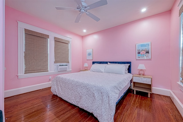 bedroom with cooling unit, wood-type flooring, and ceiling fan