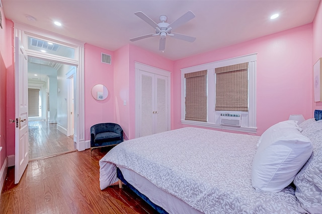 bedroom with a closet, cooling unit, hardwood / wood-style flooring, and ceiling fan