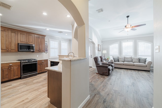 kitchen featuring light stone countertops, appliances with stainless steel finishes, light hardwood / wood-style floors, and plenty of natural light