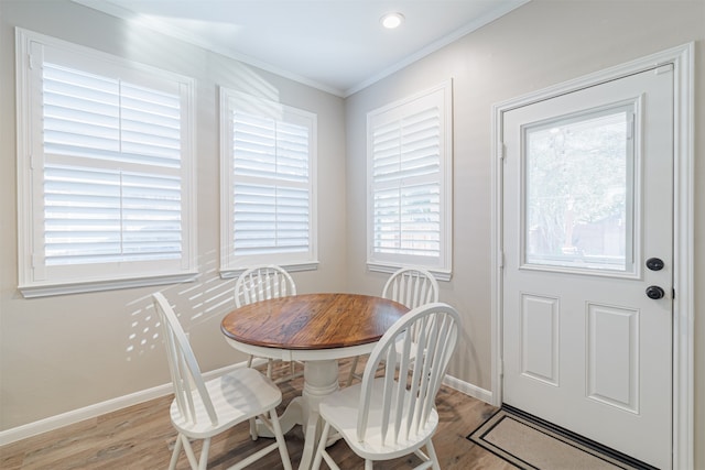 dining room with crown molding and light hardwood / wood-style flooring