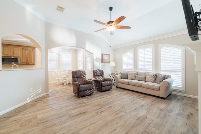 living room with ceiling fan, light wood-type flooring, ornamental molding, and lofted ceiling