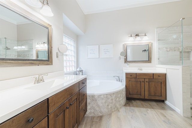 bathroom featuring crown molding, hardwood / wood-style floors, vanity, and independent shower and bath