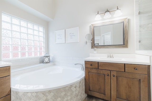 bathroom featuring vanity and tiled bath