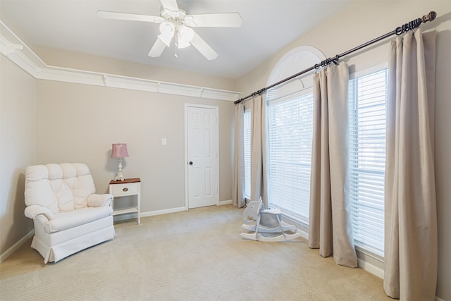 living area featuring light colored carpet and ceiling fan